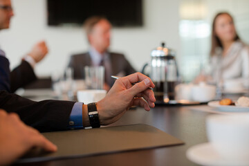 Close up of businessman's hand sitting in meeting