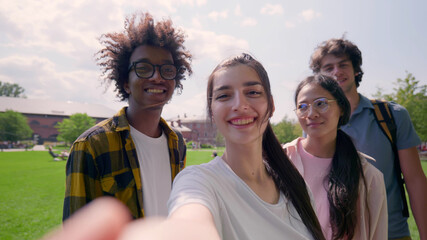 Pov shot of multiethnic young friends having video call or taking selfie together in park