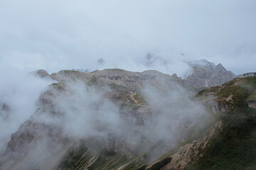 Moody picture of Dolomite peaks. Autumn in Dolomites. Huge peaks in clouds in Italy. 