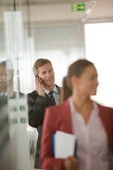 Businessman talking on cell phone in office