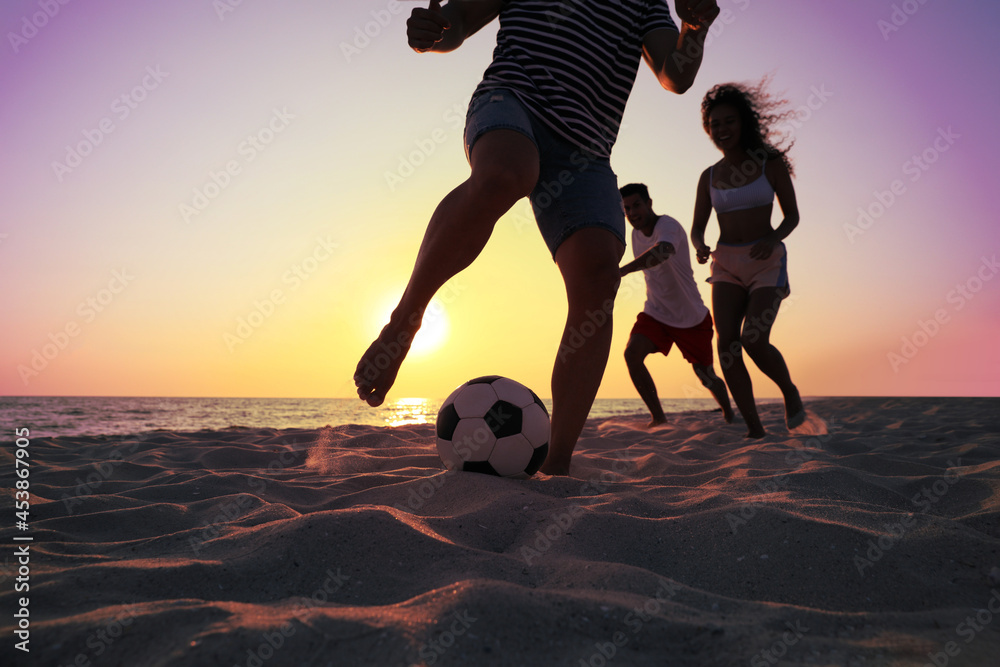 Sticker Friends playing football on beach at sunset, closeup