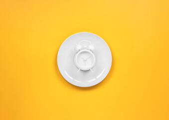 alarm clock on a dish with fork and knife