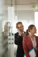Businessman talking on cell phone in office
