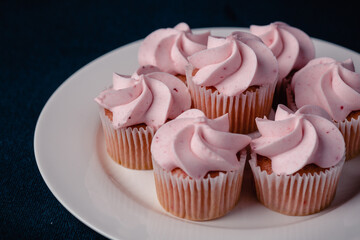 A plate of pink mini strawberry cupcakes