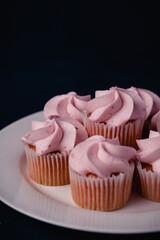 A plate of pink mini strawberry cupcakes