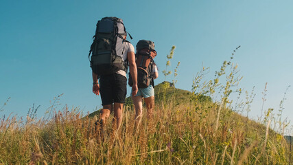 The man and woman hiking with backpacks