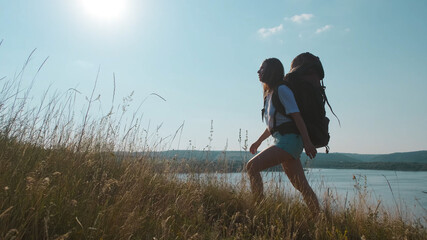 The young woman hiking with backpack along the beautiful coast
