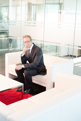 Businessman sitting on sofa in office lobby