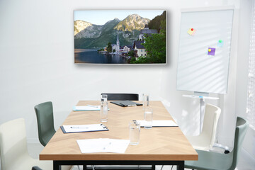 Modern wide screen TV on white wall in conference room