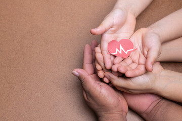 hands holding heart image with heart rate, chocolate background