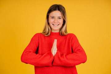 Woman smiling while keeping hands together asking something.