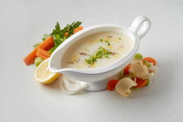 Appetizing lemon sauce served on table with assorted veggies and butter