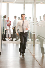 Businessman running in office hallway