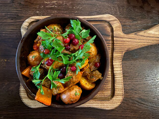 Ojahuri with veal in a brown plate is served on a plate and stands on a wooden table