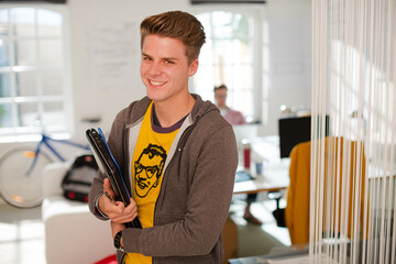 Businessman carrying folders in office
