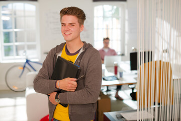 Businessman carrying folders in office