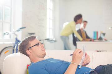 Obraz premium Businessman taking notes on sofa in office