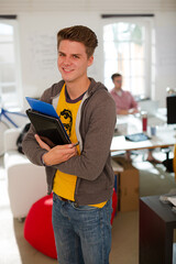 Businessman carrying folders in office