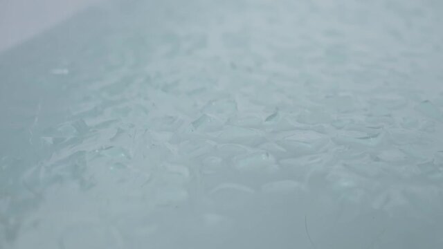 A bath full with ice cubes shaking, close up