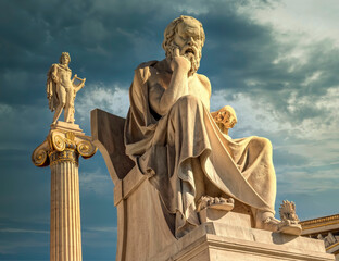 Socrates the ancient Greek philosopher and Apollo god marble statues under dramatic sky