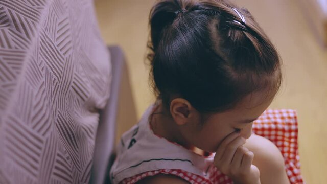 Face close up of adorable asian kid girl is lonely crying on the bedroom floor with despair, depressed, upset and sadness which is due to family or school punishment which is violence problem.