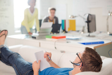 Obraz premium Businessman taking notes on sofa in office