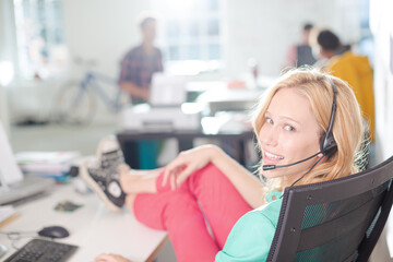 Obraz premium Businesswoman wearing headset at desk