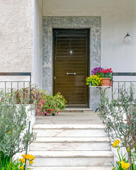 Fototapeta na wymiar contemporary family house white marble stairs with colorful potted flowers to entrance door