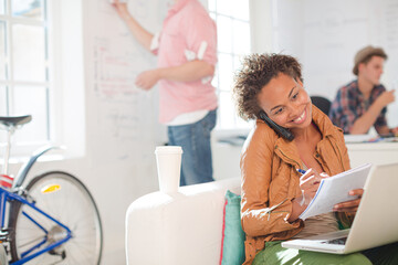 Obraz premium Businesswoman taking notes on phone in office
