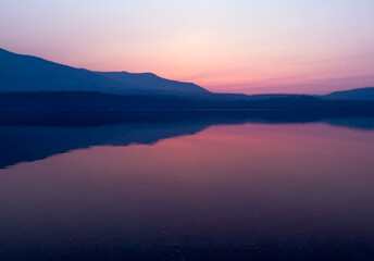 Fototapeta na wymiar Hazy purple sunset over Lake McDonald in Glacier National Park, MT