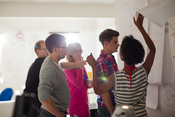 Business people reading blueprints in office