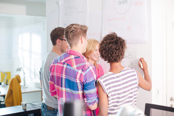 Business people reading blueprints in office