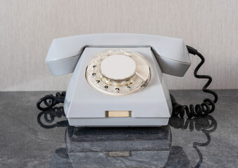 Old disused landline telephone set of gray color close-up with shadow - Powered by Adobe