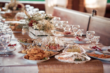 Decorated elegant wooden wedding table for banquet outdoor in garden gazebo