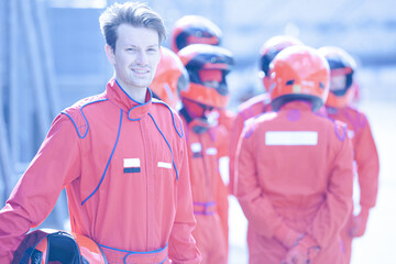 Racer holding helmet on track