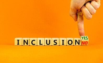 Inclusion yes or no symbol. Businessman turns a wooden cube and change words 'inclusion no' to 'inclusion yes'. Beautiful orange background. Business and inclusion yes or no concept, copy space.