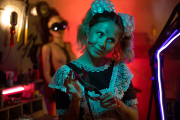 A mad schoolgirl with large bloody metal cutting pliers in her hands.