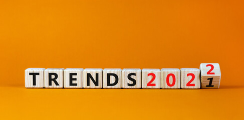 2022 trends new year symbol. Turned a wooden cube and changed words 'Trends 2021' to 'Trends 2022'. Beautiful orange background, copy space. Business, 2022 trends new year concept.