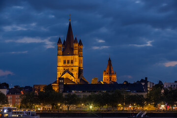 Naklejka premium Ancient buildings next to Rhine river illuminated in German city Cologne