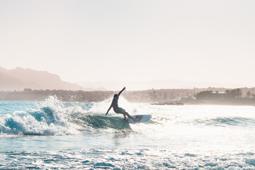 Fototapeta premium young male surfer riding a wave in the afternoon
