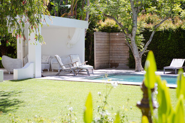 Lawn chairs and swimming pool in backyard