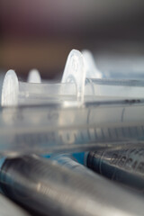 Vertical shot of several one on another empty syringes on a blurred background