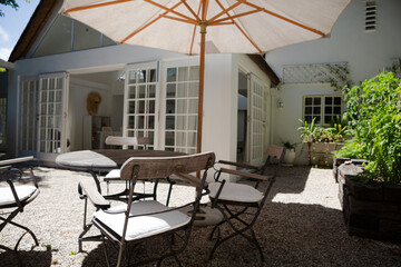 Chairs and table under umbrella in backyard
