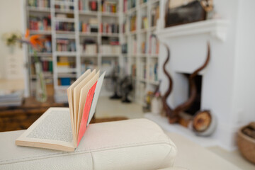 Open book on arm of sofa in living room