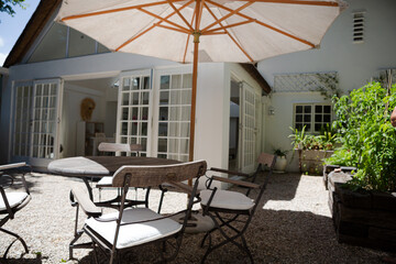 Chairs and table under umbrella in backyard