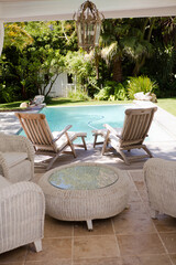 Lawn chairs and swimming pool in backyard