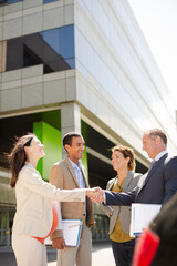 Fototapeta premium Business people shaking hands on city street