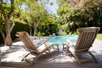 Lawn chairs and swimming pool in backyard