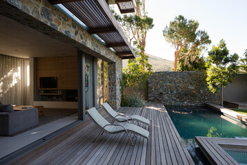 Lawn chairs and swimming pool in backyard