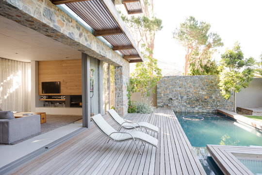 Lawn Chairs And Swimming Pool In Backyard